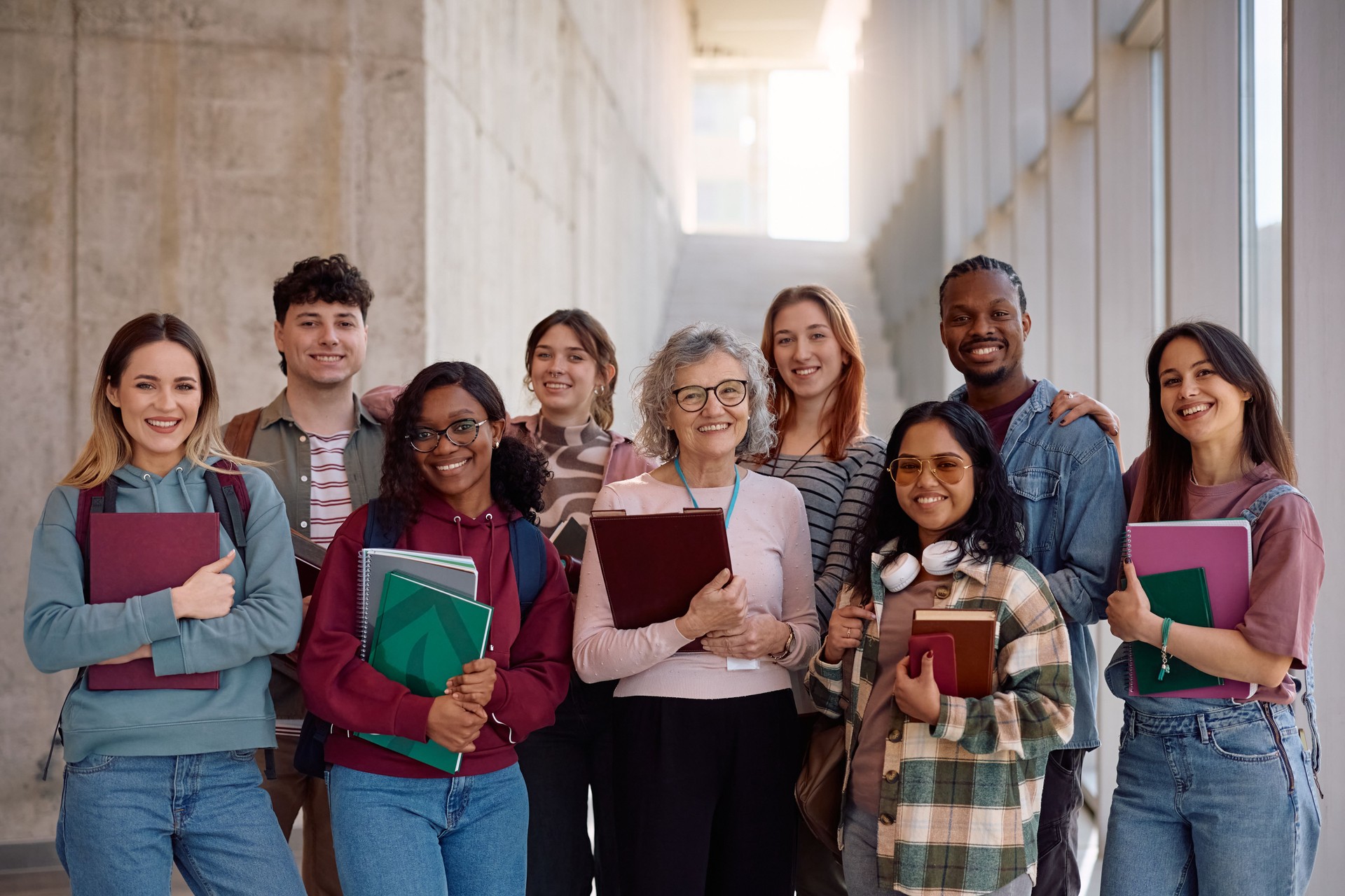 Multiracial group of students and their professor at the university looking at camera.